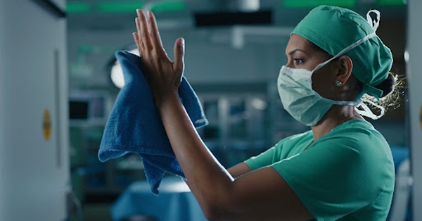 Surgeon in scrubs washing hands