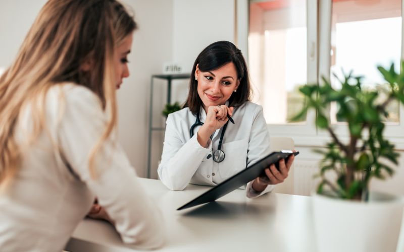 doctor explaining patient's treatment options from clipboard