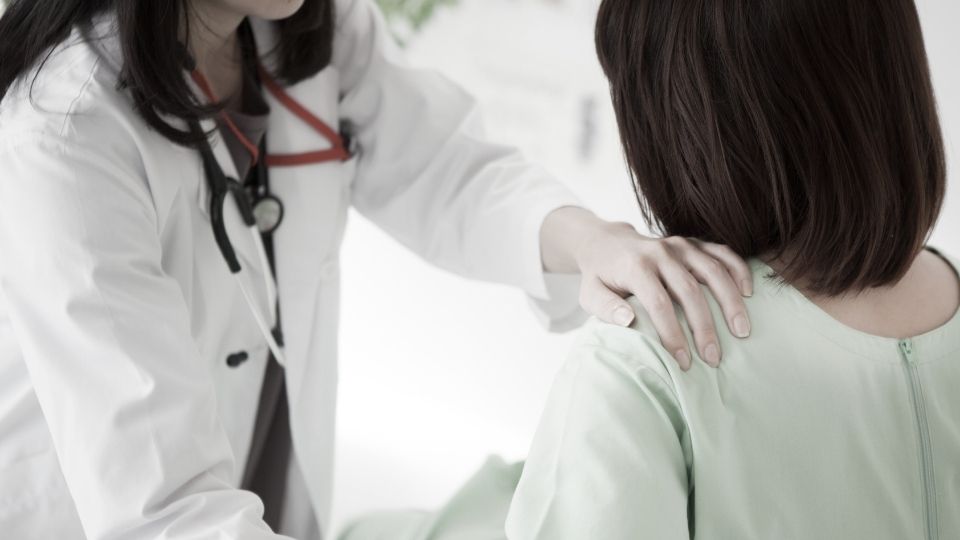 doctor examining patients shoulder